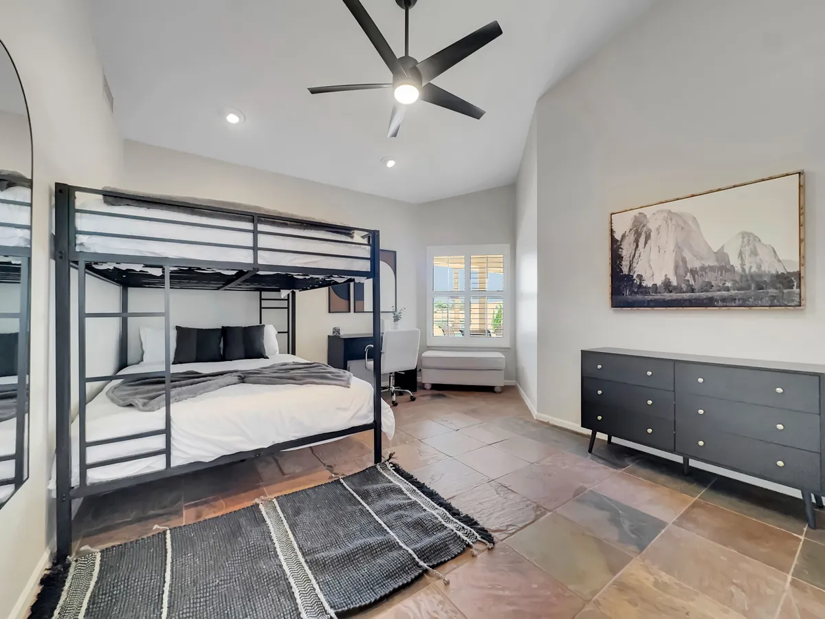 A cheerful, modern bedroom with a bunk bed, dresser, and wall art, offering a cozy environment for both resting and socializing. The setup suggests opportunities for studying, late-night gaming, or family bonding, with comfortable seating and supportive lighting.